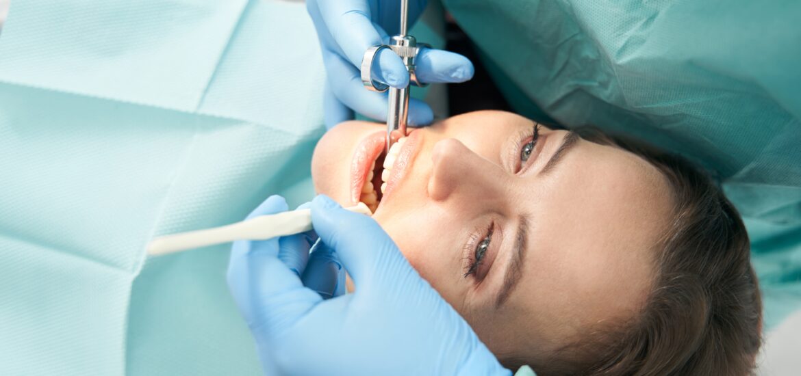 dentist performing a root canal procedure on a female patient