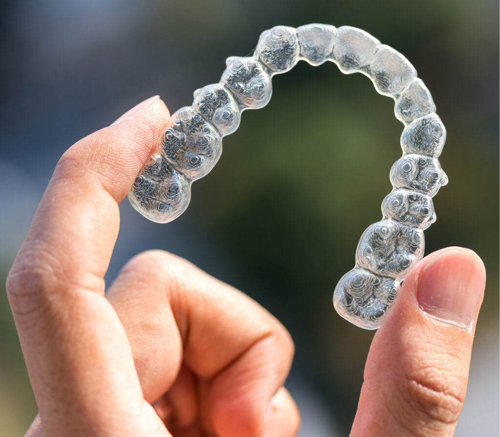 patient holding new Invisalign clear braces tray in Provo
