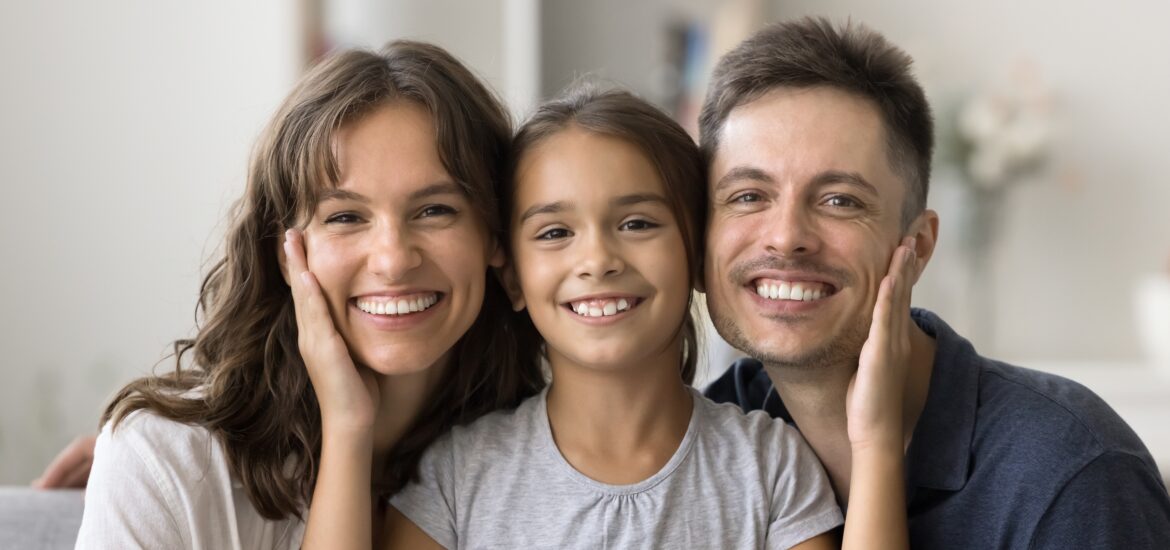 happy family smiling, little girl between mom and dad