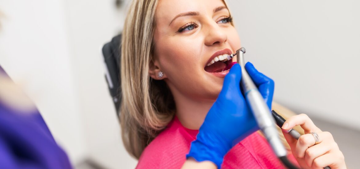 Dentist polishing patient's teeth. Young woman having her teeth repaired and polished
