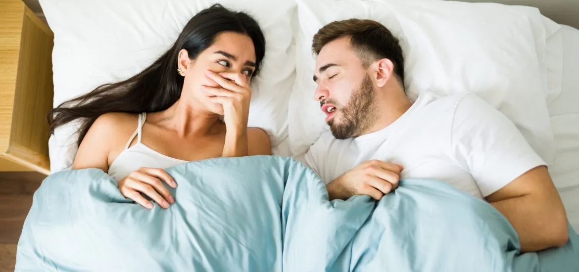 Disturbed Latina covering her nose because of her partner's bad breath in bed